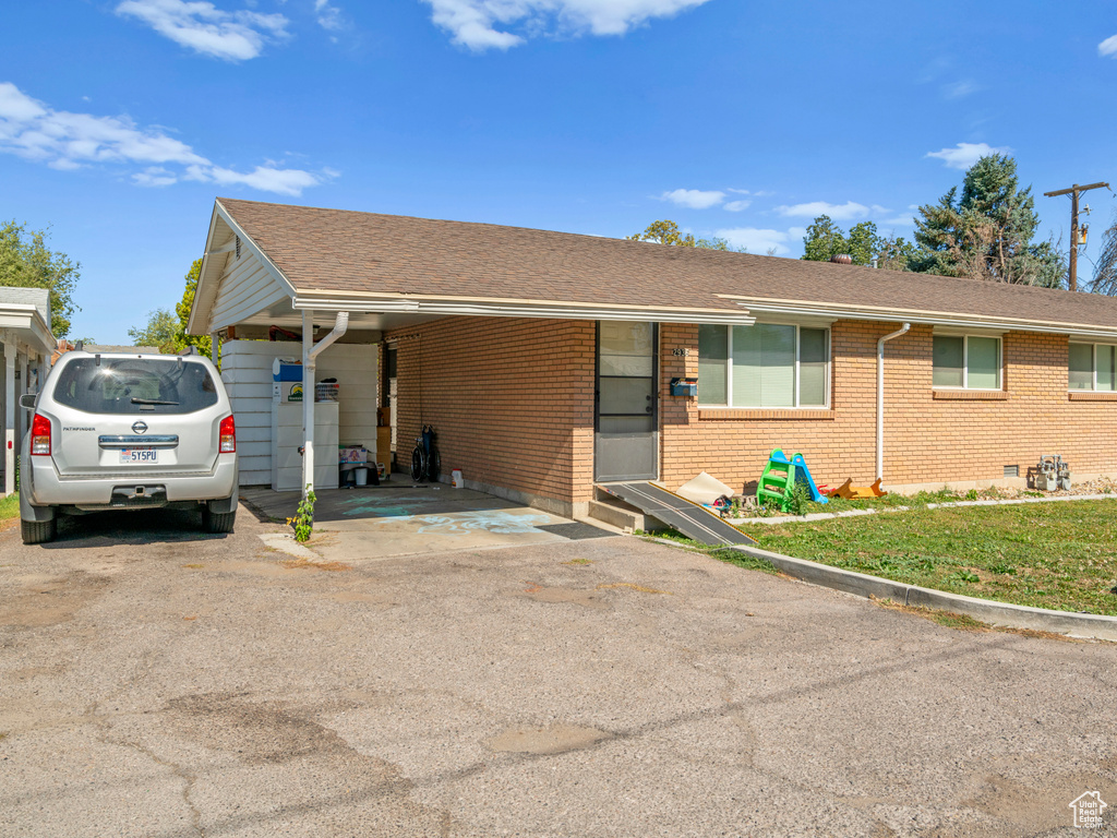 Ranch-style home with a front yard and a carport