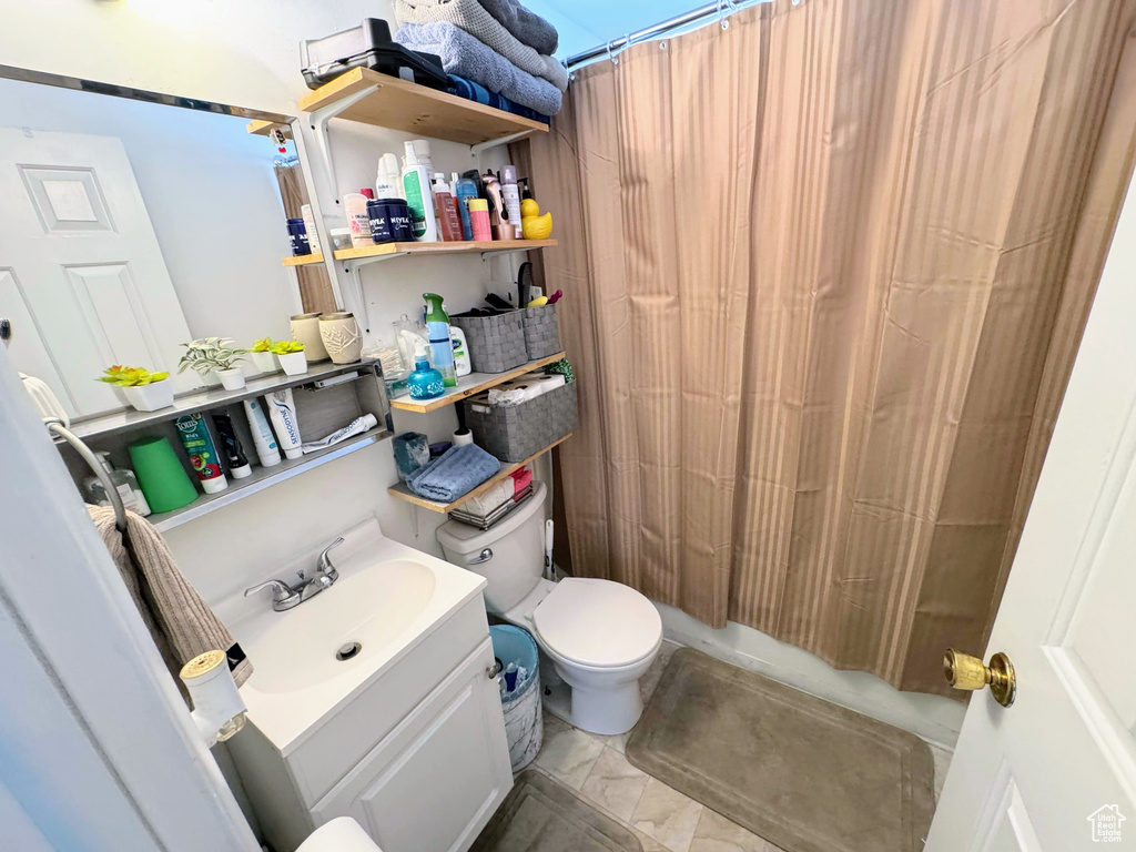 Full bathroom featuring shower / bath combination with curtain, vanity, and toilet