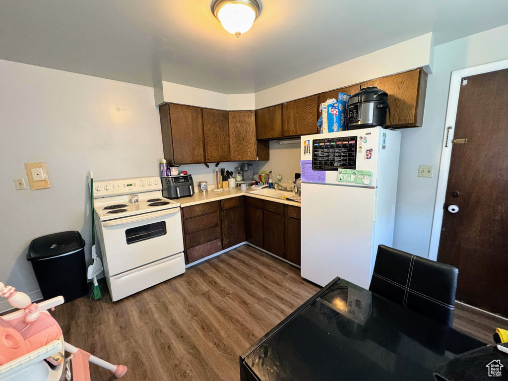 Kitchen featuring white appliances, dark hardwood / wood-style floors, and sink