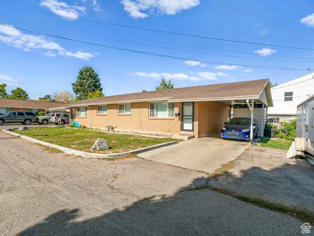 Single story home with a front yard and a carport