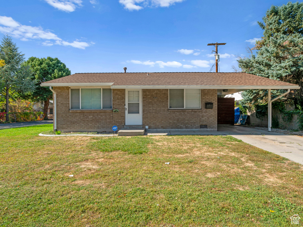 Single story home with a front lawn and a carport