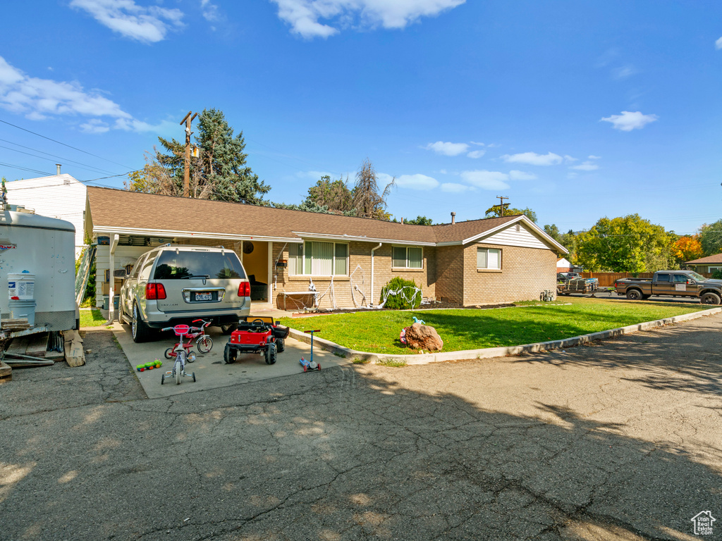 Ranch-style home featuring a front lawn