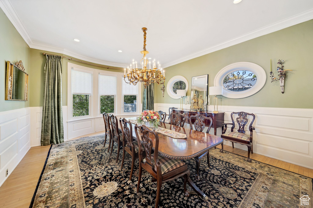 Dining space featuring crown molding, a notable chandelier, and light wood-type flooring