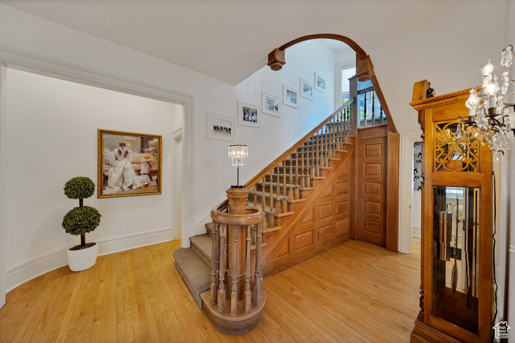 Staircase featuring hardwood / wood-style floors and a towering ceiling