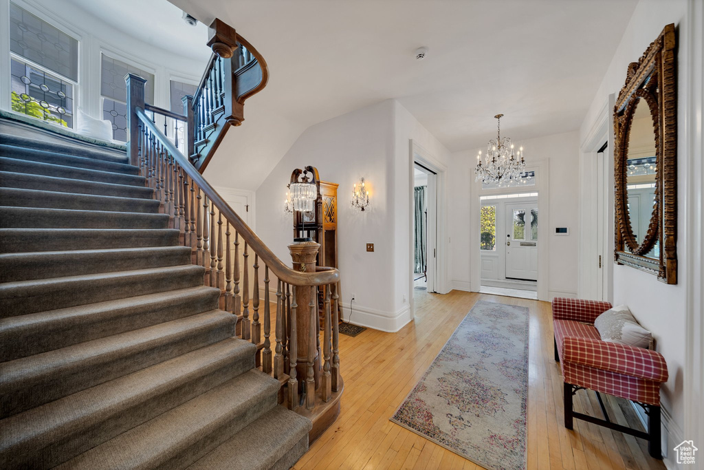 Foyer entrance featuring a notable chandelier and light wood-type flooring