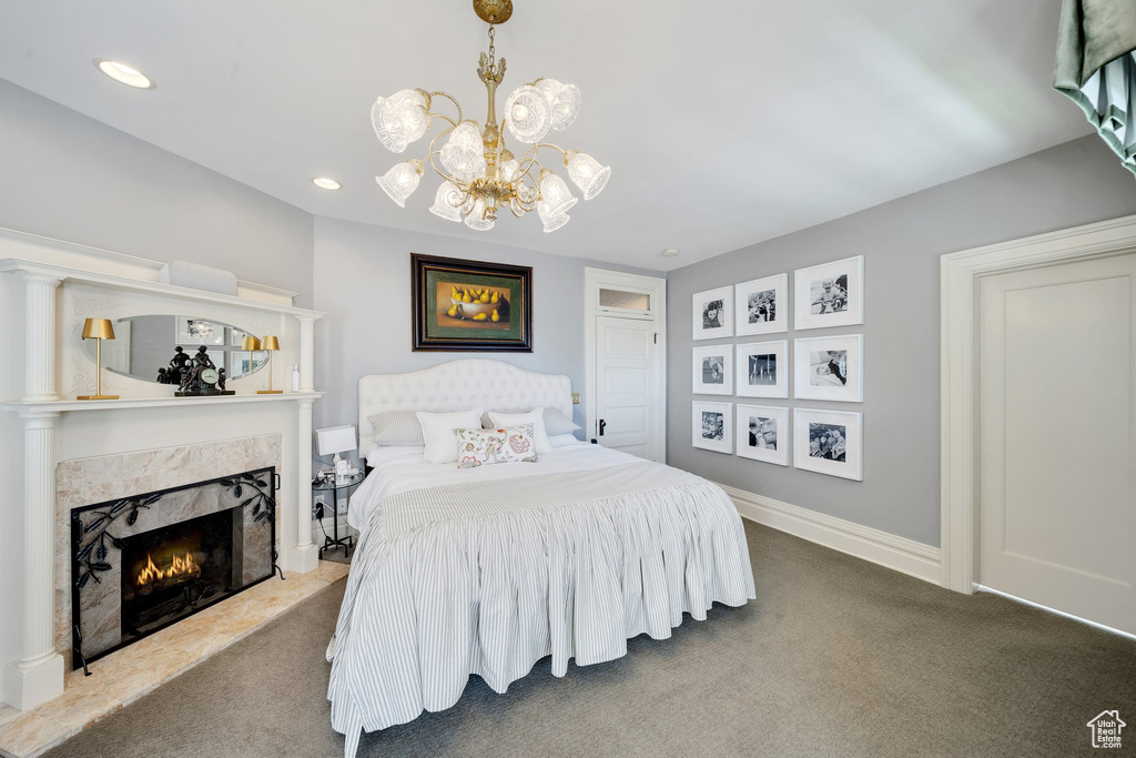 Bedroom featuring carpet, a chandelier, and a high end fireplace