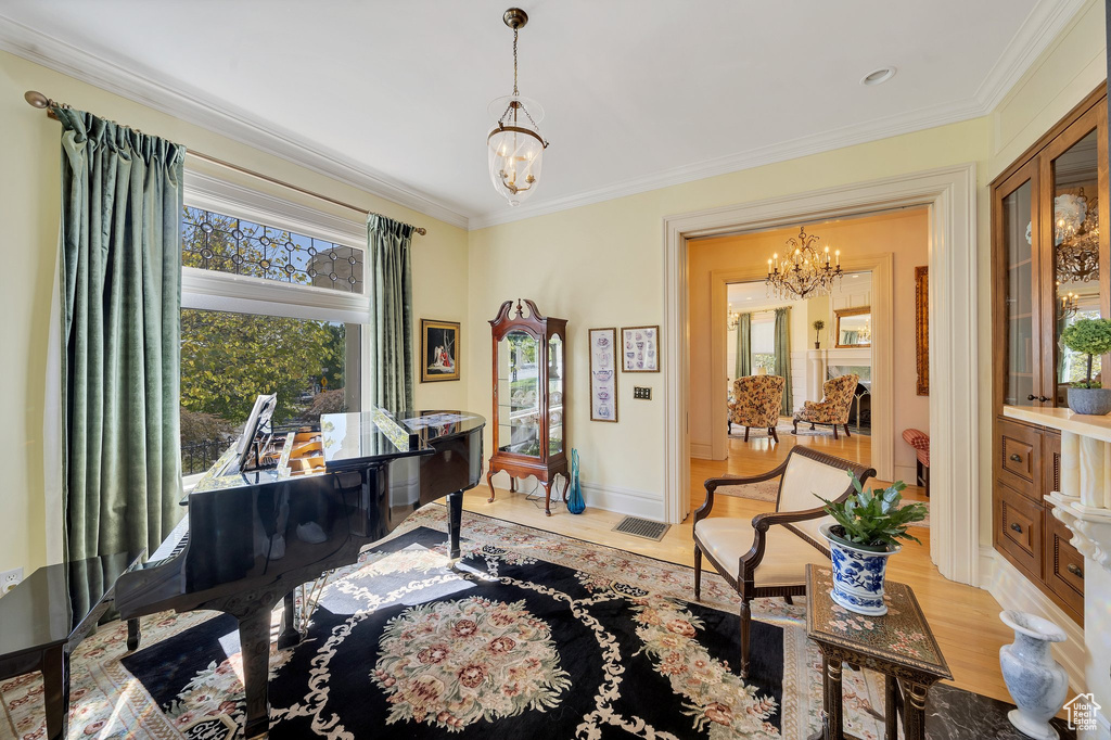 Interior space featuring light hardwood / wood-style floors, crown molding, and a chandelier