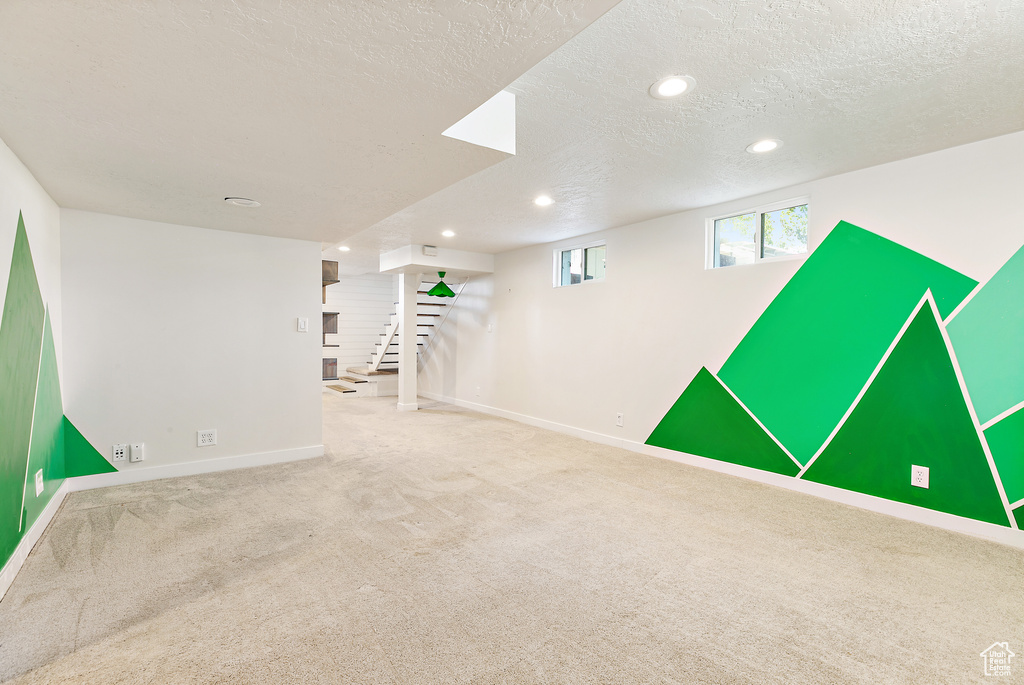 Basement with carpet floors and a textured ceiling