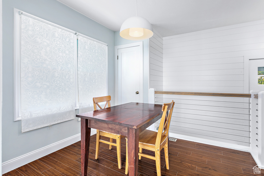 Dining area featuring wooden walls and dark hardwood / wood-style floors