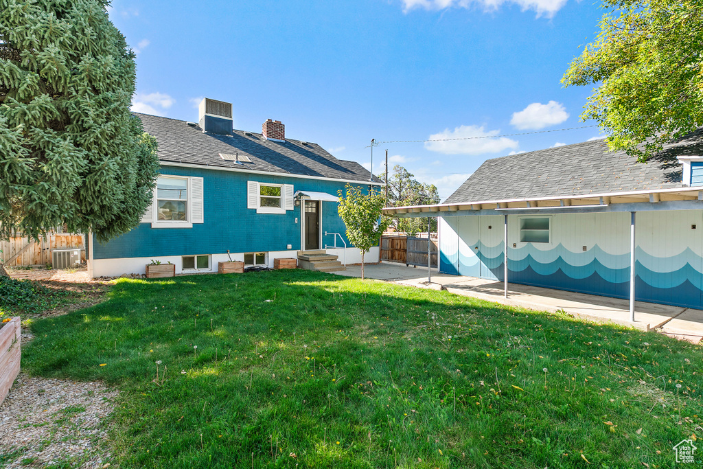 Rear view of house with a patio, a yard, and central AC unit