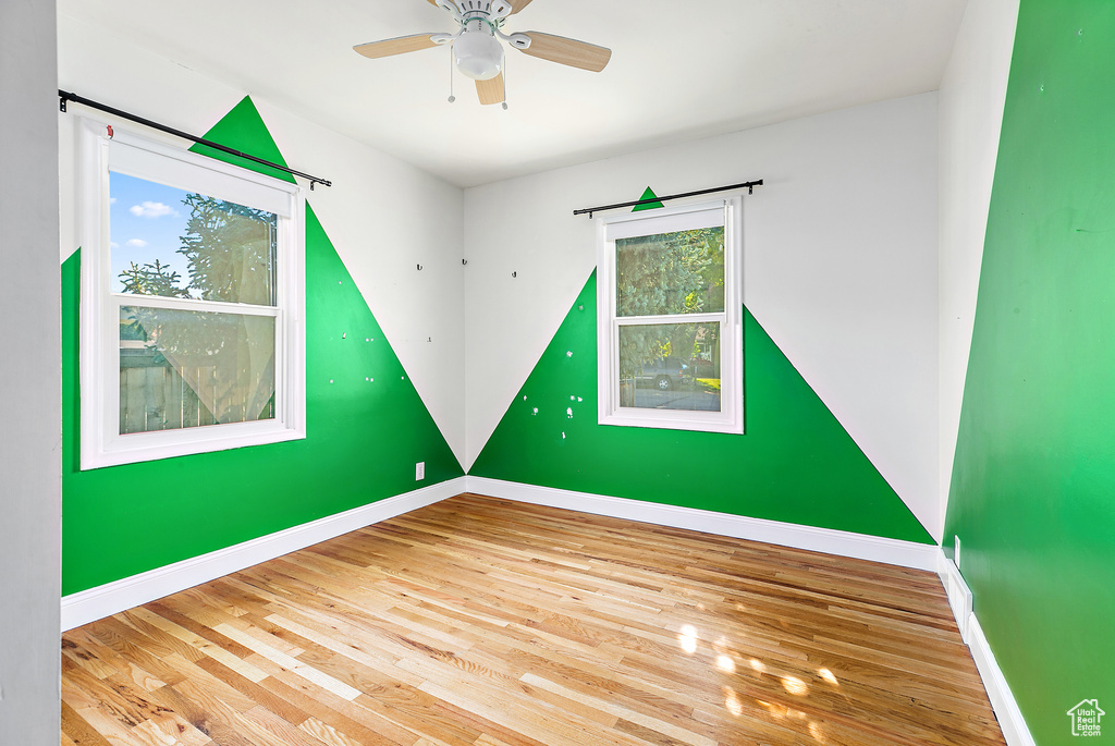 Unfurnished room with ceiling fan, a wealth of natural light, and light hardwood / wood-style floors