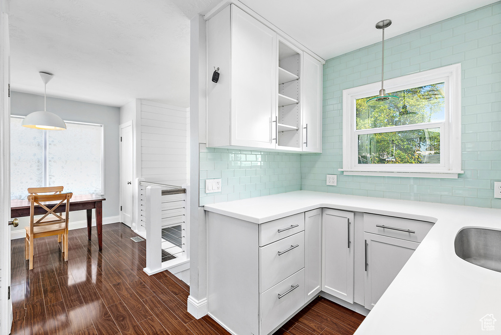 Kitchen featuring pendant lighting, dark hardwood / wood-style flooring, and white cabinetry