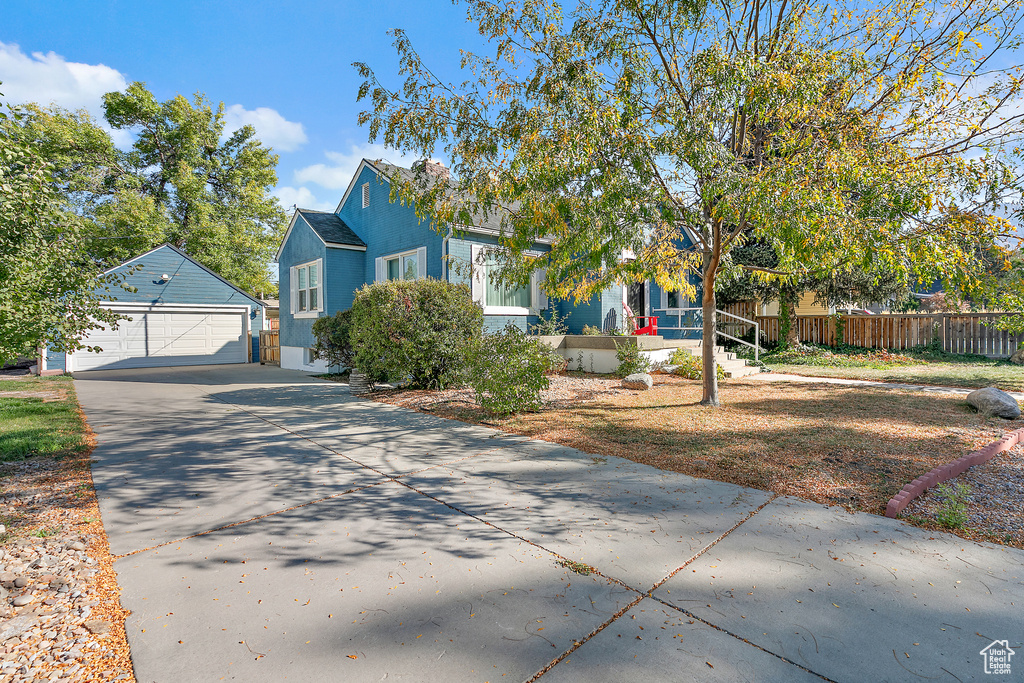 View of front of home with a garage and an outdoor structure