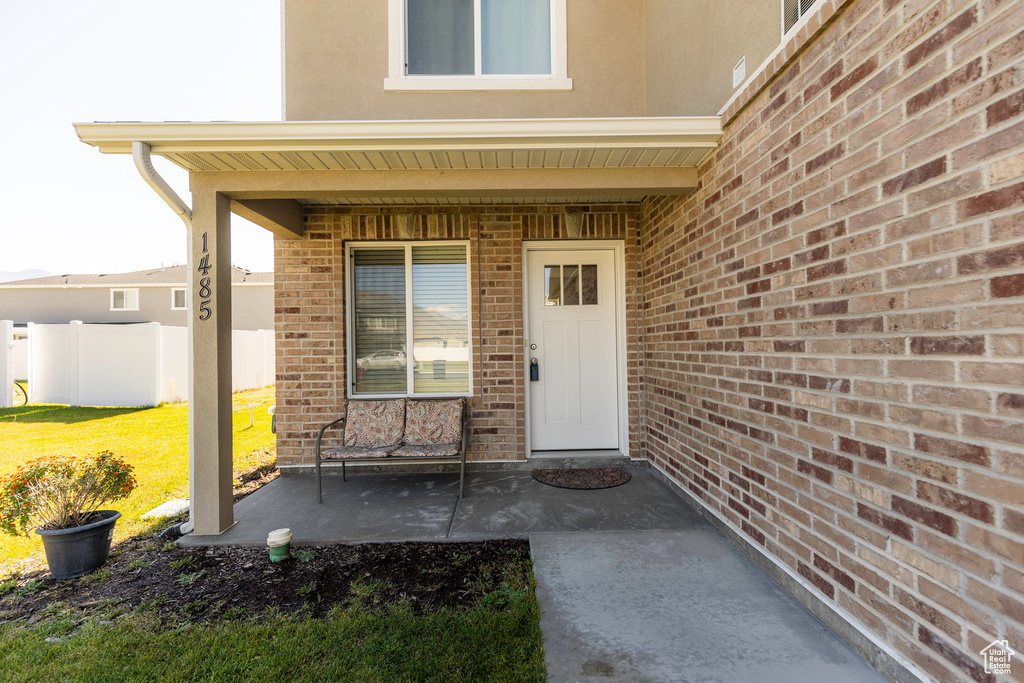 View of exterior entry featuring a lawn