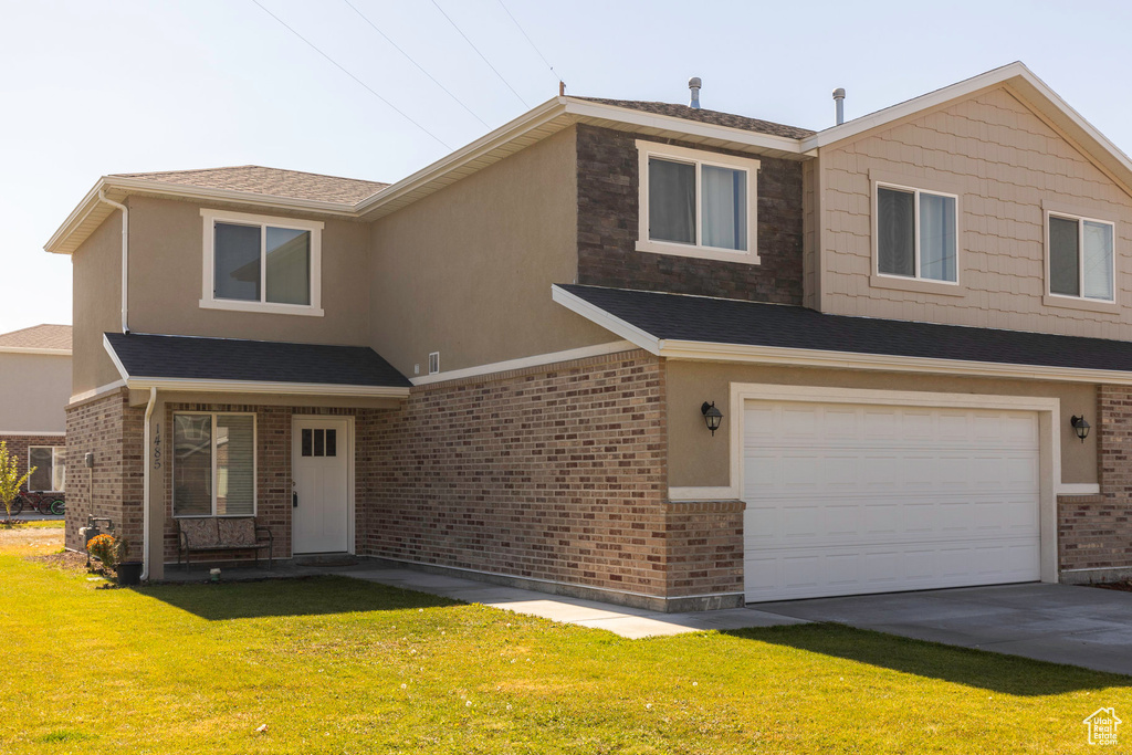 View of front facade with a front yard and a garage