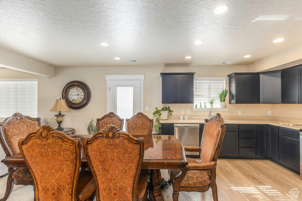 Dining area featuring a textured ceiling and light hardwood / wood-style floors