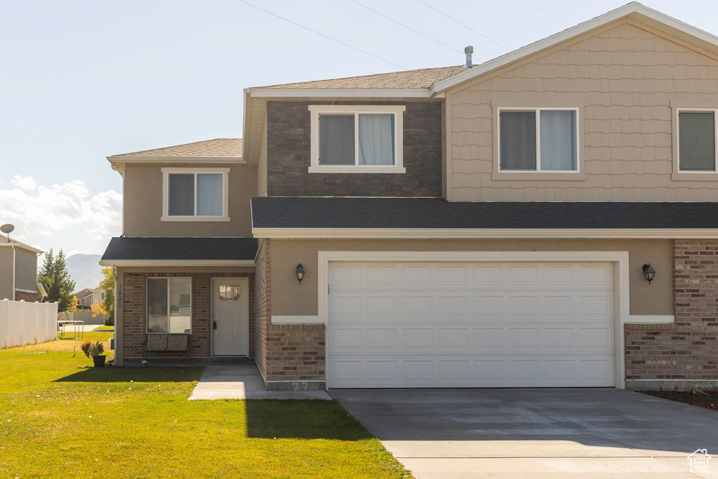 View of front of property with a front yard and a garage