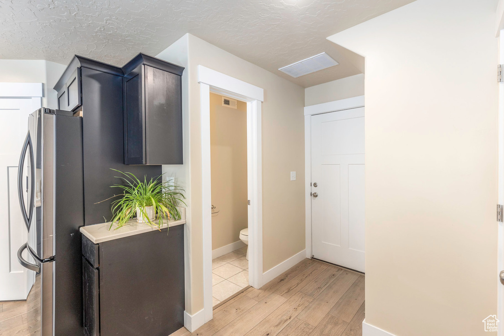 Interior space with a textured ceiling and light hardwood / wood-style flooring