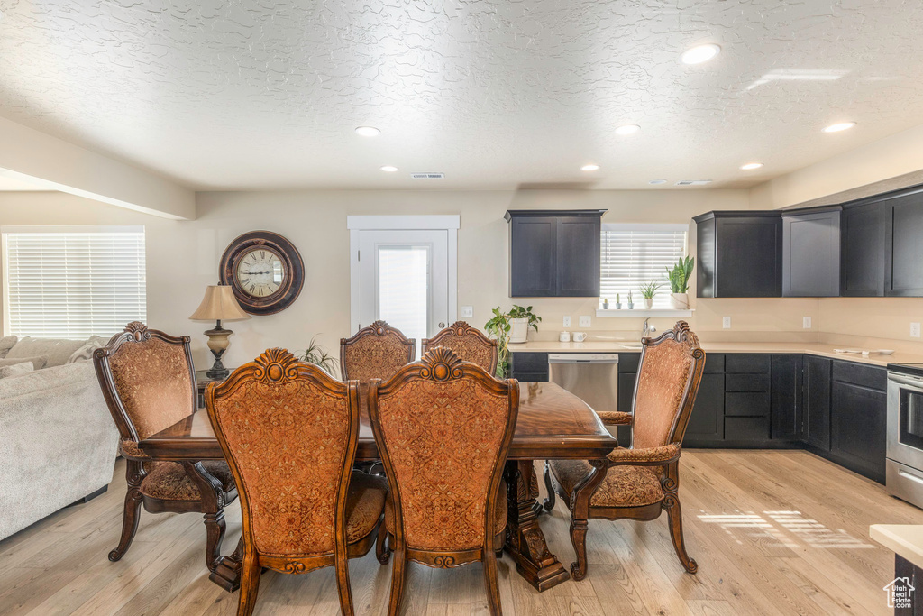 Dining area featuring a textured ceiling and light hardwood / wood-style flooring