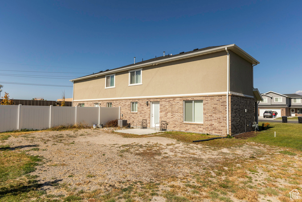 Rear view of house with a patio and a lawn