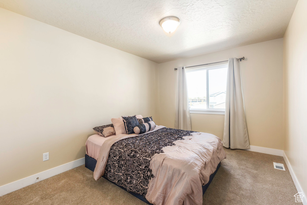 Carpeted bedroom with a textured ceiling