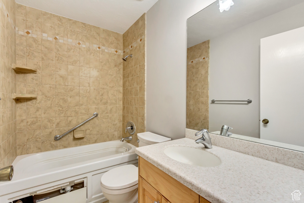 Full bathroom with toilet, vanity, and tiled shower / bath combo