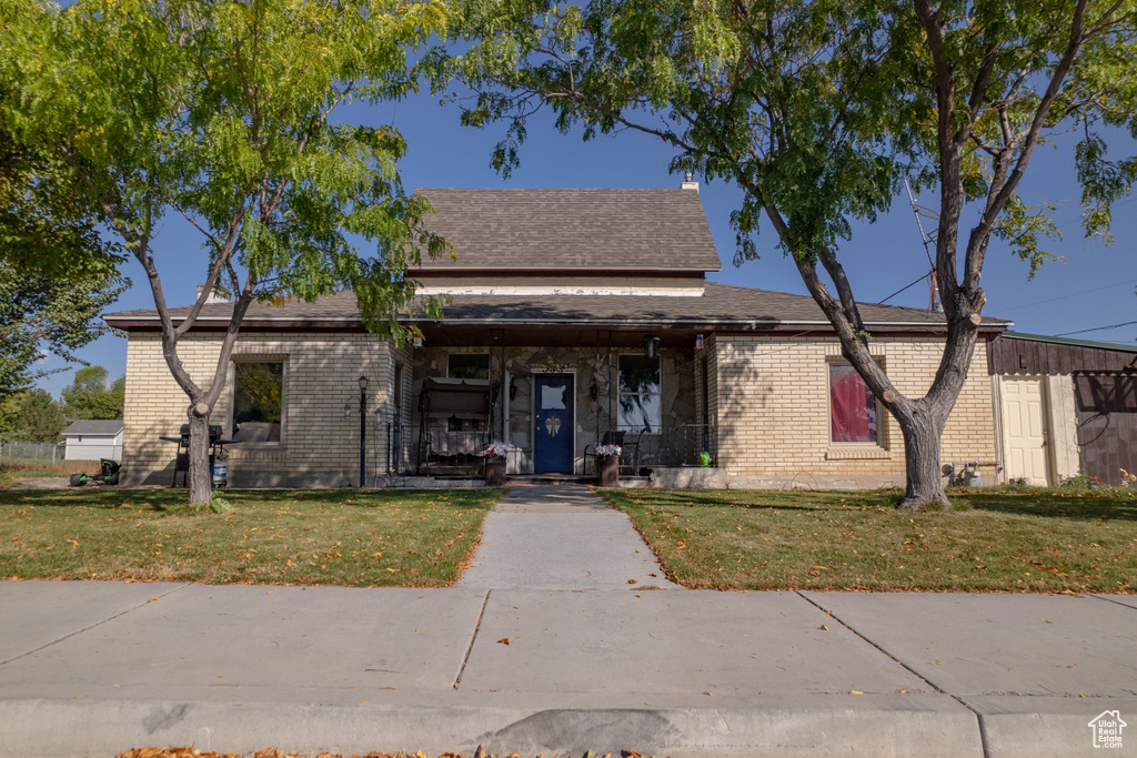 View of front of house featuring a porch and a front yard