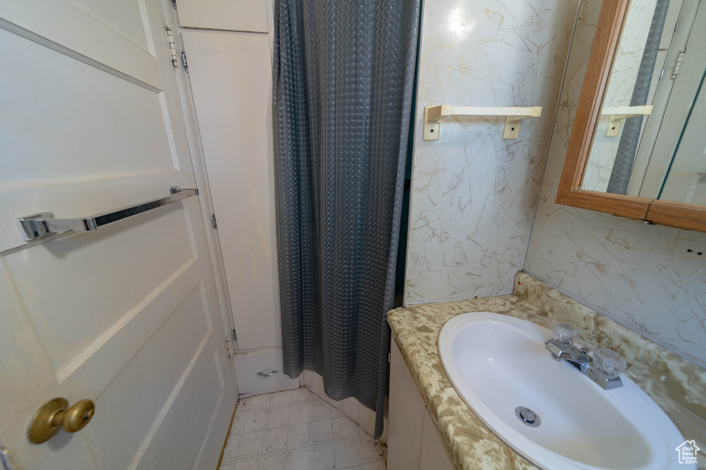 Bathroom featuring a shower with curtain and vanity