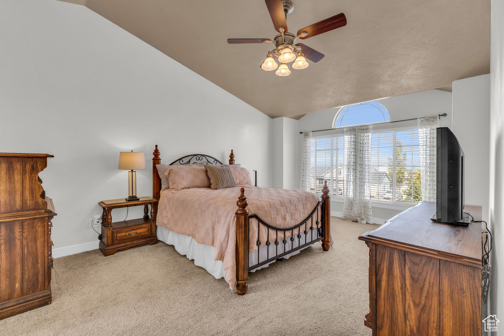 Bedroom featuring ceiling fan, vaulted ceiling, and light colored carpet