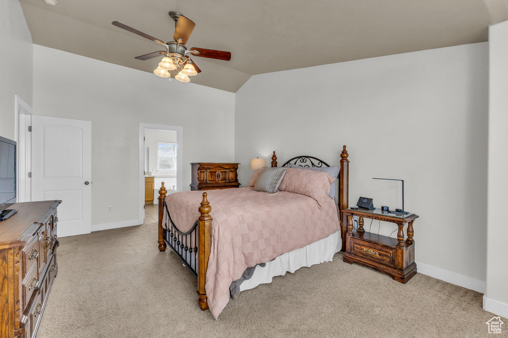 Bedroom featuring ceiling fan, light carpet, and vaulted ceiling