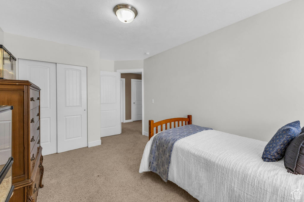 Carpeted bedroom with a closet