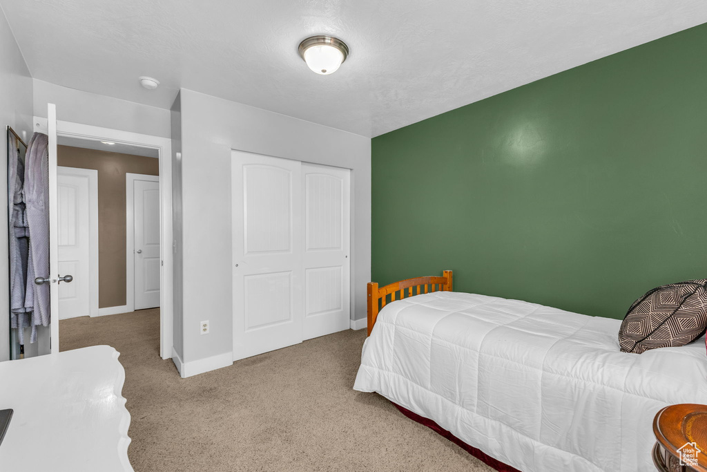 Carpeted bedroom with a closet