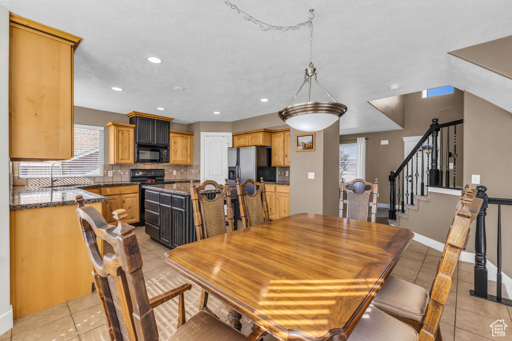 Tiled dining space featuring sink and a textured ceiling