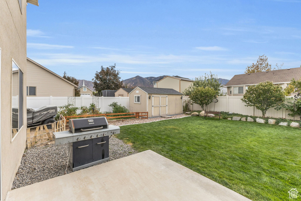 View of yard with a storage unit and a patio area