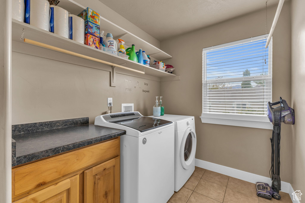 Clothes washing area with independent washer and dryer and light tile patterned floors