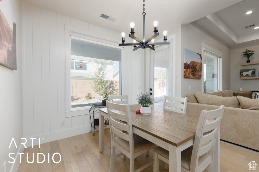 Dining space featuring a notable chandelier and light hardwood / wood-style flooring