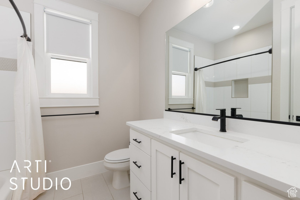 Bathroom featuring walk in shower, a healthy amount of sunlight, vanity, and toilet