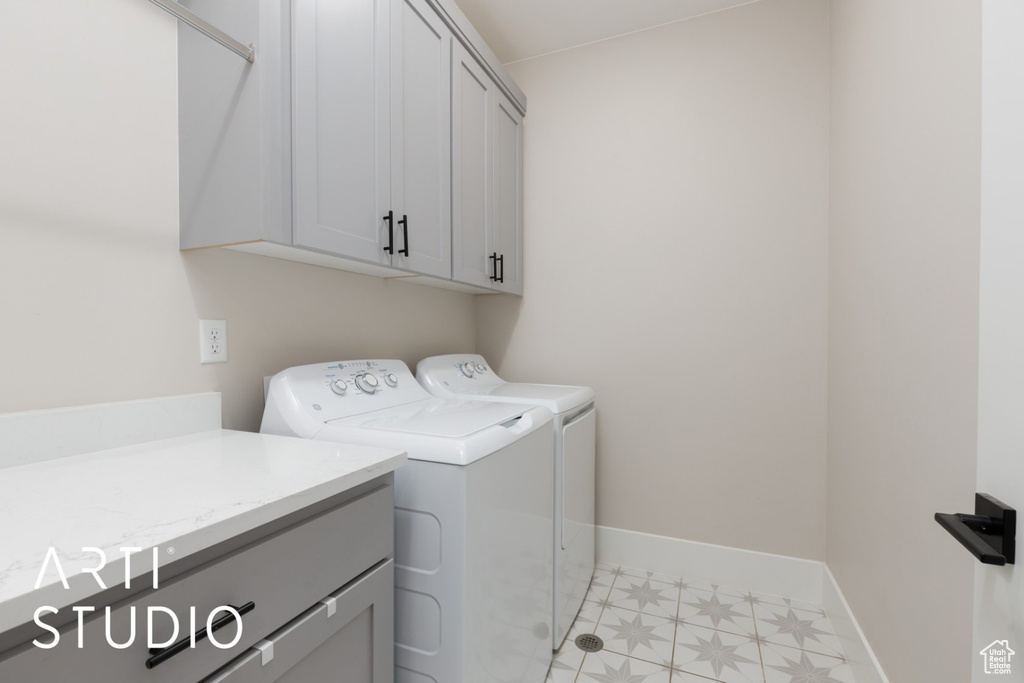 Laundry room with washer and clothes dryer and cabinets