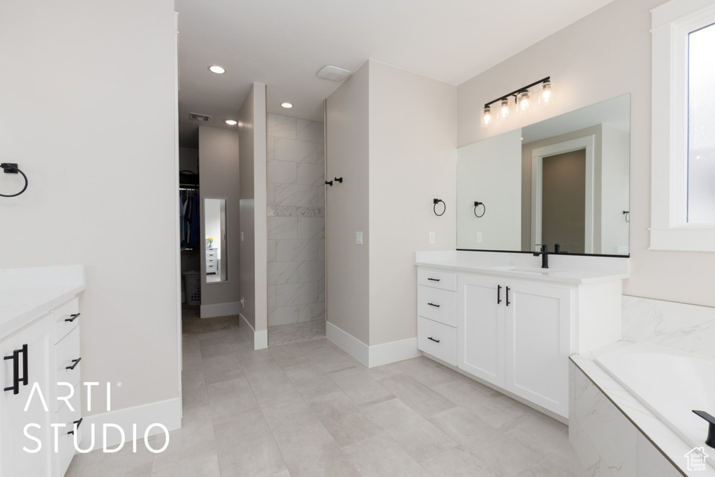 Bathroom with tile patterned floors, vanity, and independent shower and bath