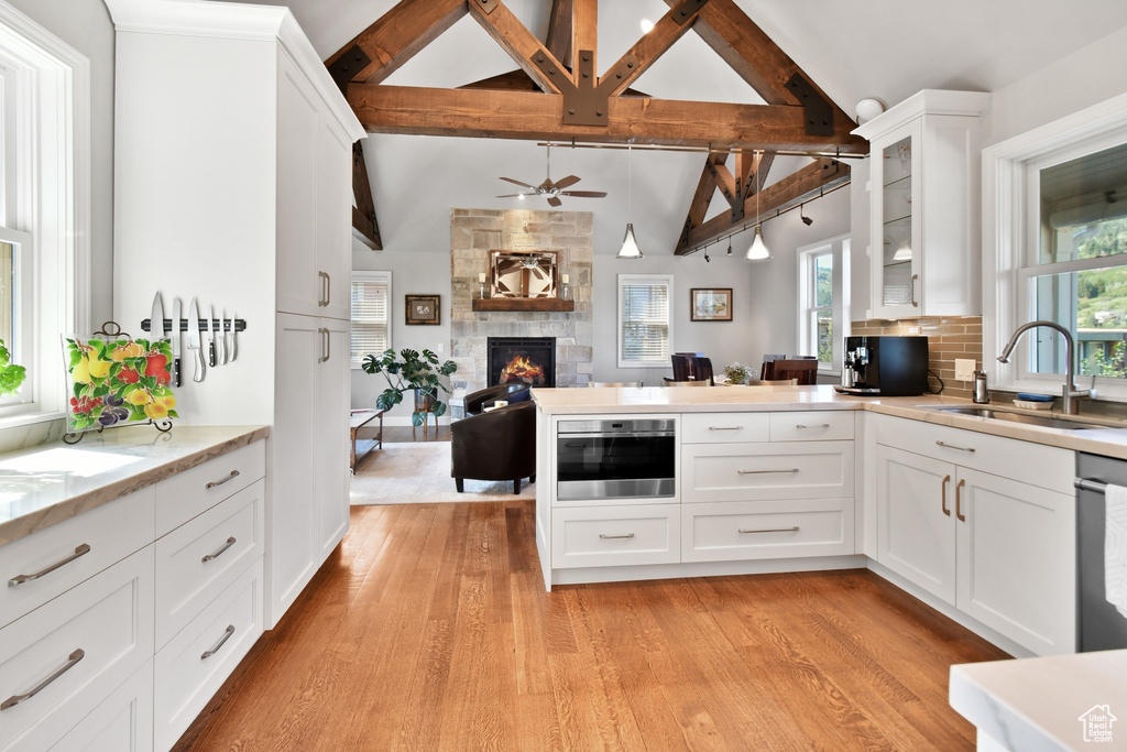 Kitchen featuring light wood-type flooring, plenty of natural light, sink, and white cabinetry