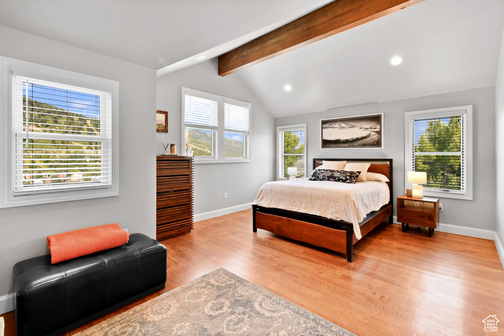 Bedroom featuring lofted ceiling with beams and light hardwood / wood-style floors