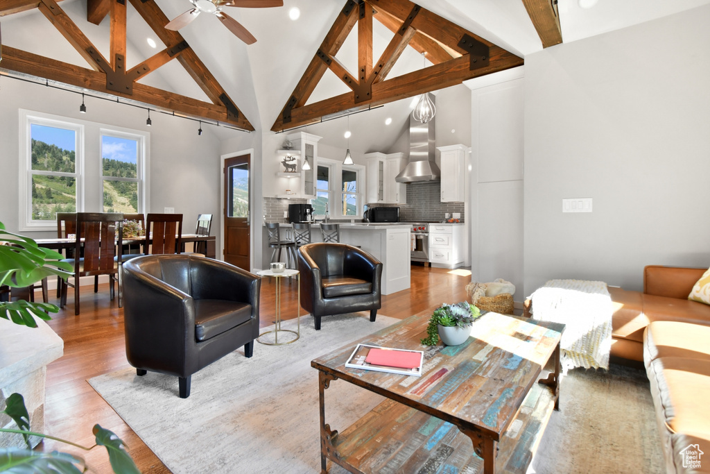 Living room featuring light wood-type flooring, beam ceiling, and high vaulted ceiling