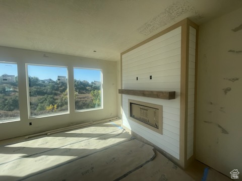 Unfurnished living room with a fireplace and a healthy amount of sunlight