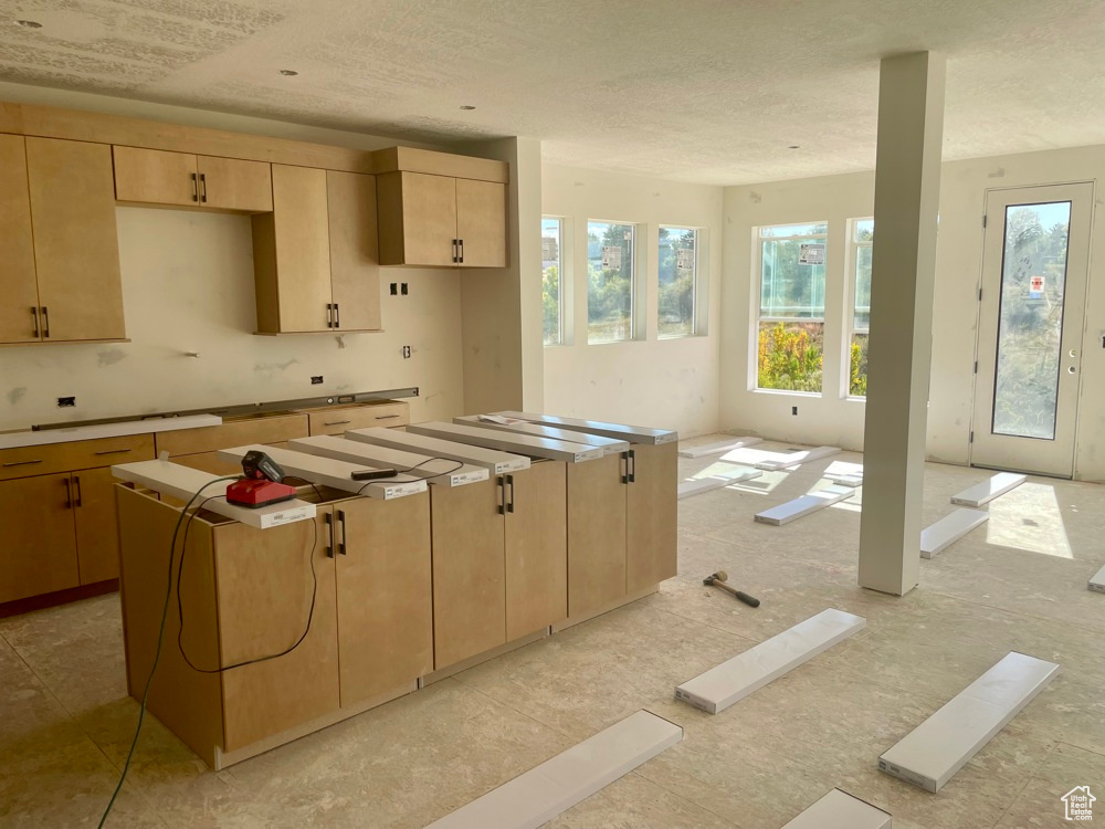 Kitchen featuring a center island and light brown cabinets