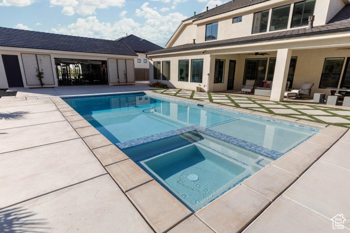 View of swimming pool featuring an in ground hot tub, ceiling fan, and a patio area