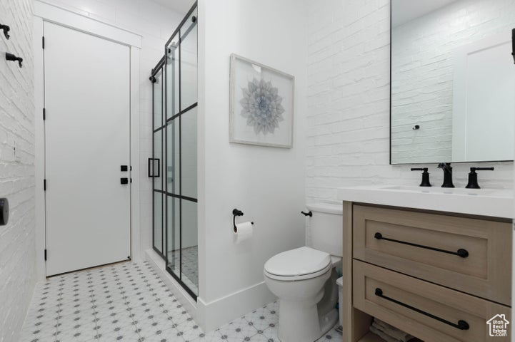 Bathroom featuring walk in shower, vanity, and toilet