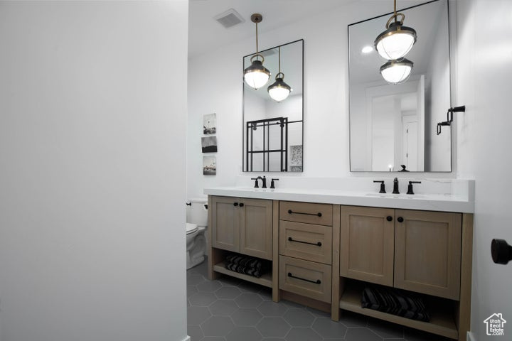 Bathroom with tile patterned flooring, vanity, and toilet