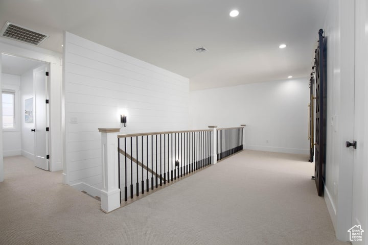 Corridor with light colored carpet