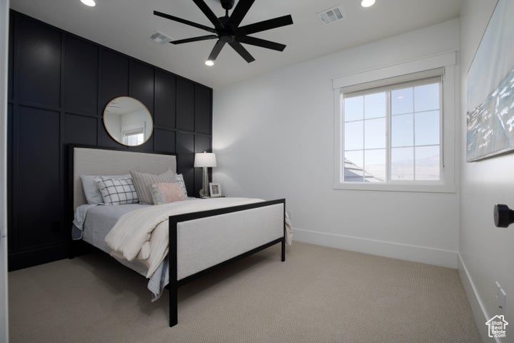 Carpeted bedroom featuring ceiling fan