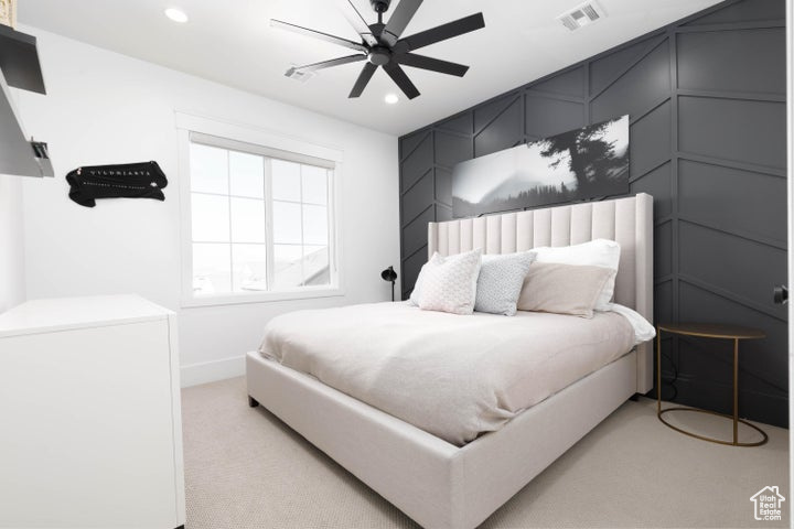 Bedroom with ceiling fan and light colored carpet